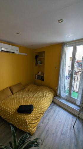 une chambre avec un lit et une grande fenêtre dans l'établissement Appartement Cosy, au Boulou