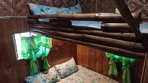 Cama en habitación con techo de madera en Moalboal Bamboo House / Rooms, en Moalboal
