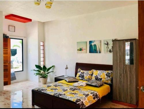 um quarto com uma cama com uma colcha amarela em Jean apartments em Panglao
