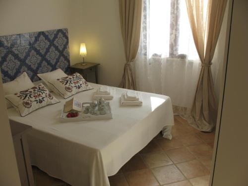 Zimmer mit einem weißen Bett und einem Fenster in der Unterkunft Agave Scopello in Scopello