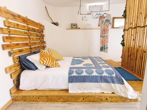 a bedroom with a bed with a wooden headboard at Pé n' Areia by Ericeira Property in Carvoeira