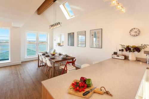 kuchnia i salon ze stołem z warzywami na ladzie w obiekcie Appledore home with panoramic estuary view w mieście Appledore