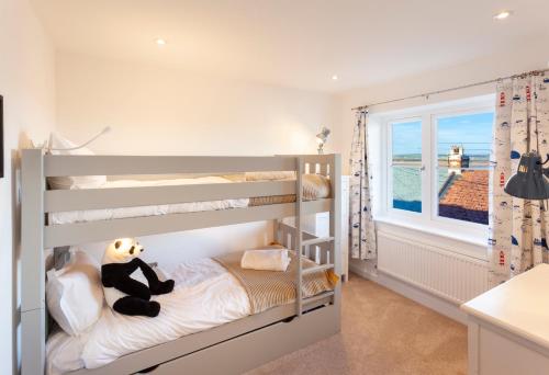 sypialnia z łóżkiem piętrowym z misiem na łóżku w obiekcie Appledore home with panoramic estuary view w mieście Appledore