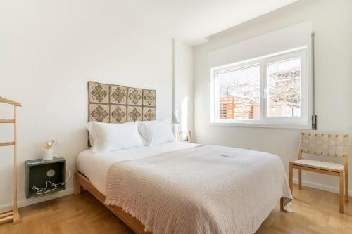 a white bedroom with a bed and a window at Porto Lidador Boutique Ap with Garden - Alvaro in Porto