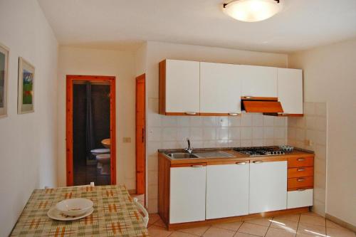 a small kitchen with white cabinets and a table at Apartments Villa Franca in Capoliveri in Capoliveri