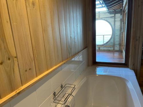 eine Badewanne in einem Zimmer mit Fenster in der Unterkunft Loerie Lodge in Keurboomstrand