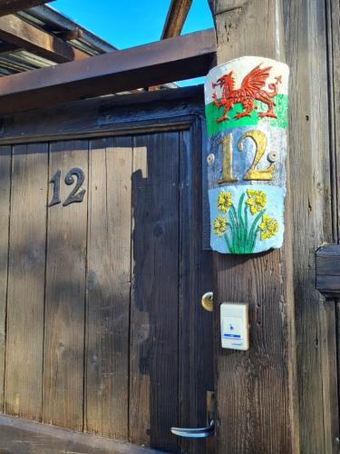 een houten deur met een bord erop bij Lymore Guest house in Palamarza