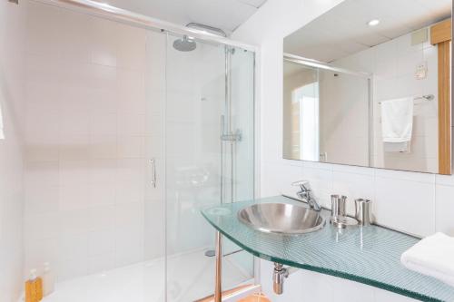 La salle de bains est pourvue d'un lavabo en verre et d'une douche. dans l'établissement The Best Barcelona, à Barcelone
