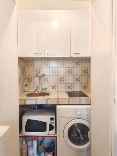 une cuisine avec un lave-linge et un micro-ondes dans l'établissement Appartement 4 personnes au centre Paris - Chatelet, à Paris