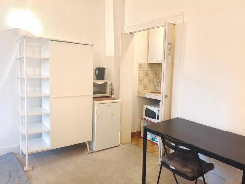 een kleine keuken met een bureau en een koelkast bij Appartement 4 personnes au centre Paris - Chatelet in Parijs