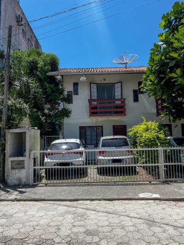 twee auto's geparkeerd voor een huis bij Kitnet no Melhor Ponto de Bombinhas in Bombinhas