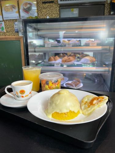 uma mesa com um prato de comida e uma chávena de café em HOTEL GATAO em Sobral