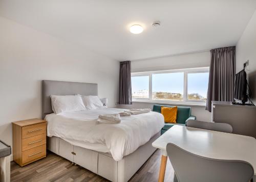 a bedroom with a bed and a desk and a table at Late Rooms at North Devon Resort in Ilfracombe