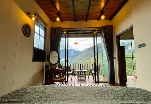 a bedroom with a bed and a balcony with a view at The Capoe House in Haputale
