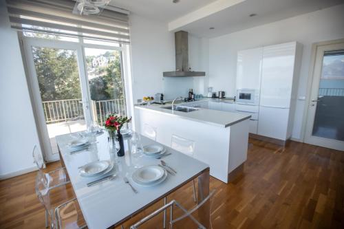 a kitchen with white counters and a white counter top at Sunset - The Twin Villa in Široka