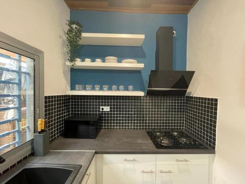 a kitchen with a black and white tiled wall at Mado Coliving - Studio Appart, Chambre coin cuisine, Chambre in Douala