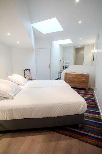 a bedroom with two beds and a dresser in it at Centre historique vue cathédrale in Lisieux
