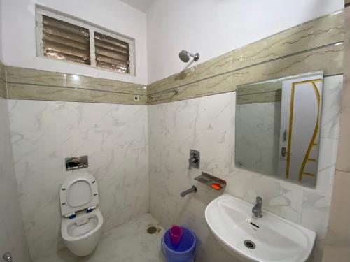 a bathroom with a toilet and a sink and a mirror at Hotel Plaza Rooms in Hyderabad