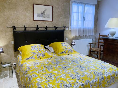 sypialnia z łóżkiem z żółtą pościelą i żółtymi poduszkami w obiekcie Appartement de vacances - VILLA L'OLIVIER w mieście Vaux-sur-Mer