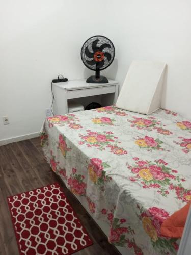 a bedroom with a bed with a floral comforter at Apartamento no Pelourinho in Salvador
