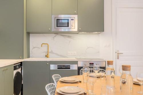 a kitchen with a table with chairs and a microwave at 5-bedroom house in the centre of Lille. in Lille