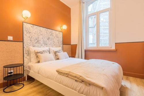 a bedroom with a large bed with orange walls and a window at 5-bedroom house in the centre of Lille. in Lille