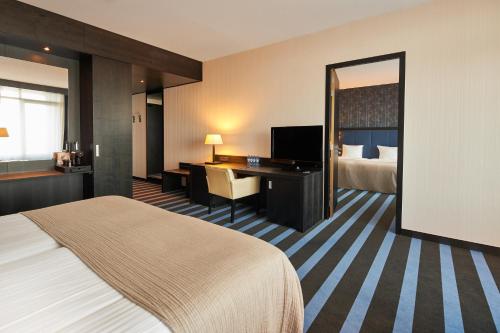 スネークにあるヴァン デル ヴァルク ホテル スニークのベッドとデスクが備わるホテルルームです。