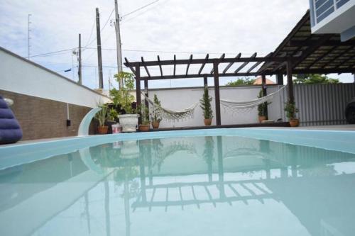 uma piscina com uma pérgula ao lado de uma casa em Casa de Alto Padrão próxima ao Beto Carrero em Navegantes