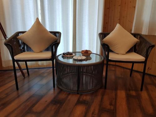 two chairs and a glass table with two chairs at The Woods Retreat in Lansdowne