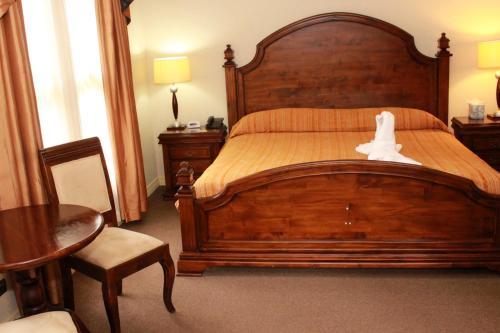 a bedroom with a large wooden bed with a white bird on it at Sportsmens Lodge - Gentlemen's Club in San José