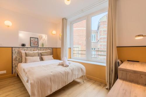 une chambre avec un lit et une grande fenêtre dans l'établissement 5-bedroom house in the centre of Lille., à Lille