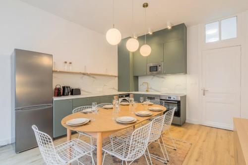 uma cozinha com uma mesa e cadeiras numa cozinha em 5-bedroom house in the centre of Lille. em Lille