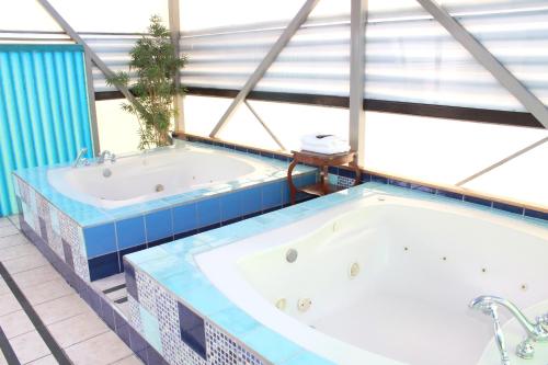 a large bathroom with two jacuzzi tubs at Sportsmens Lodge - Gentlemen's Club in San José