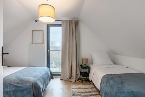 a bedroom with two beds and a window at W SAM LAS in Lubenia