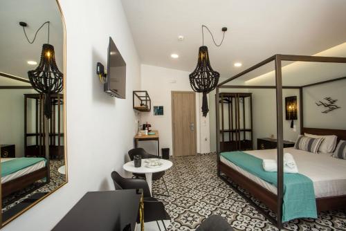 a room with two beds and a table and a mirror at Marini Seaside in Faliraki