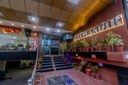 a lobby of a restaurant with stairs and potted plants at Hotel Raj Mandir in Haridwār