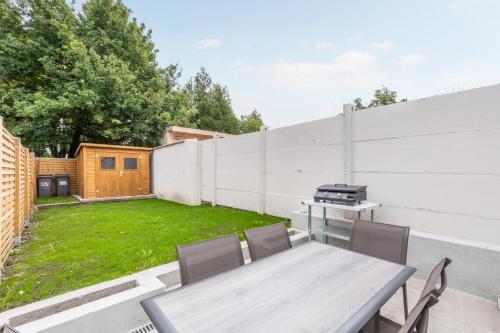 um quintal com uma mesa e cadeiras e uma cerca em 3 bedroom house with garden, free parking em Marcq-en-Baroeul