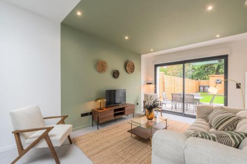 un salon avec un canapé et une télévision dans l'établissement 3 bedroom house with garden, free parking, à Marcq-en-Barœul