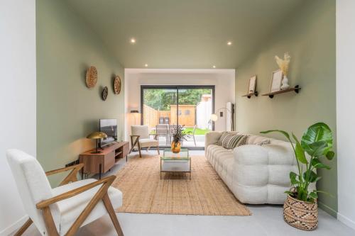uma sala de estar com um sofá branco e uma mesa em 3 bedroom house with garden, free parking em Marcq-en-Baroeul