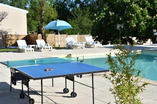 a ping pong table next to a swimming pool at Sauvignon in Monestier