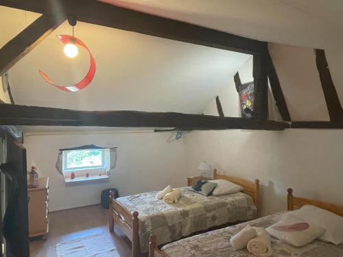 a bedroom with two beds in a room with beams at Sauvignon in Monestier
