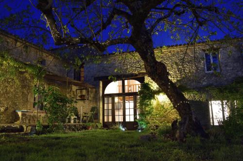 an old stone house with a tree in the yard at Sauvignon in Monestier
