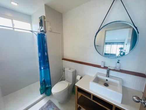 La salle de bains est pourvue de toilettes, d'un lavabo et d'un miroir. dans l'établissement The Seacraze, à Hua Hin