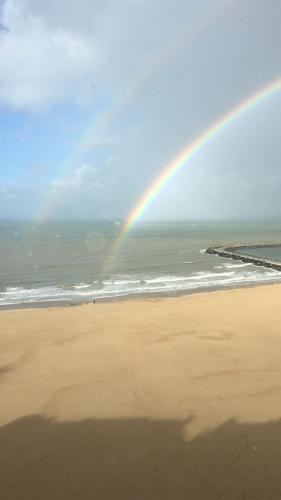a rainbow on a beach with the ocean at Seaview Loft in Ostend