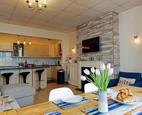 陶因的住宿－Beach Front Apartment in Tywyn，厨房以及带鲜花桌的客厅。