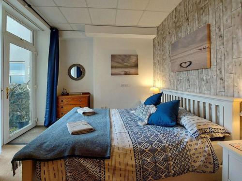 a bedroom with a large bed with blue pillows at Beach Front Apartment in Tywyn in Tywyn
