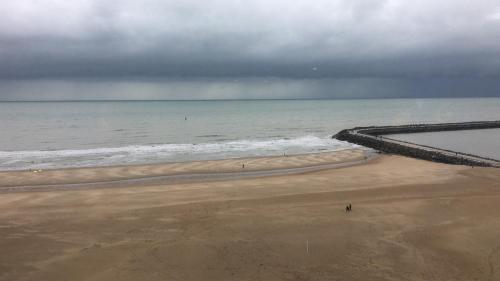 a beach with the ocean on a cloudy day at Seaview Loft in Ostend