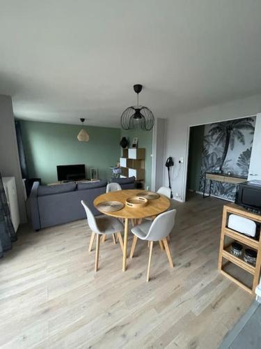 - un salon avec une table, des chaises et un canapé dans l'établissement Appartement urbain à deux pas de la plage, au Havre