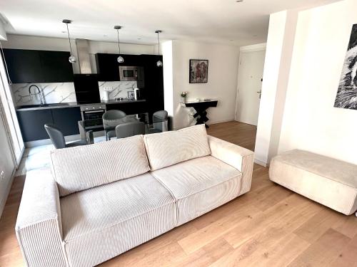 un salon avec un canapé blanc et une cuisine dans l'établissement GRAND T2 PROCHE VELODROME ET MER, à Marseille