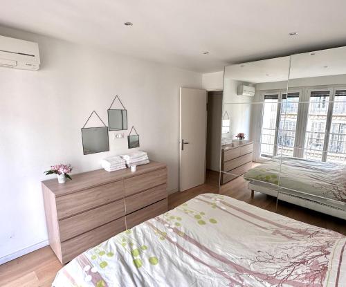 une chambre avec un lit et un grand miroir dans l'établissement GRAND T2 PROCHE VELODROME ET MER, à Marseille